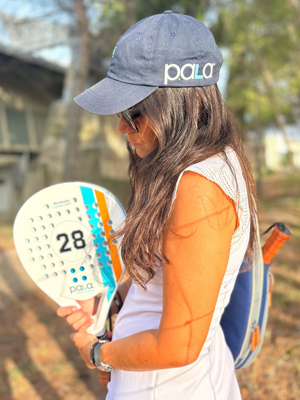 beginner padel racket white female player holding the racket with a blue padel bag